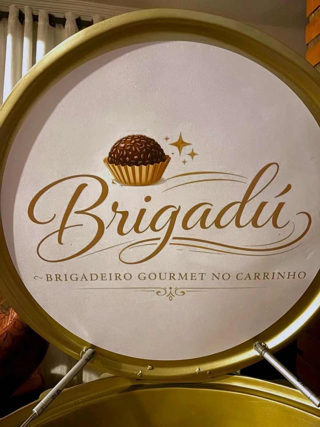 Detalhe da tampa do carrinho Brigadú com o logotipo dourado em relevo